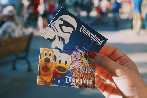 Woman holding two tickets for Disneyland