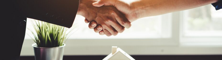 Agent and client shaking hands after signed house selling document